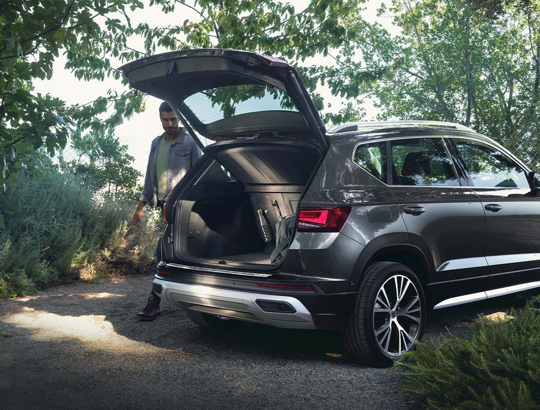 A man satanding next to the Seat Atcea with rear bumper protector